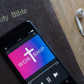 Bible with phone and headphones,Concept listen the words of God.Bible, phone and earphones on wood table.